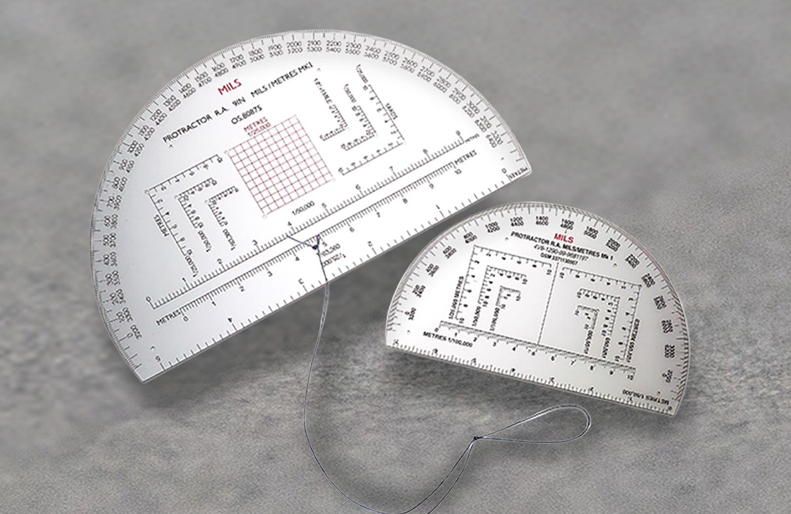 A set of military-grade protractors, attached by a string.