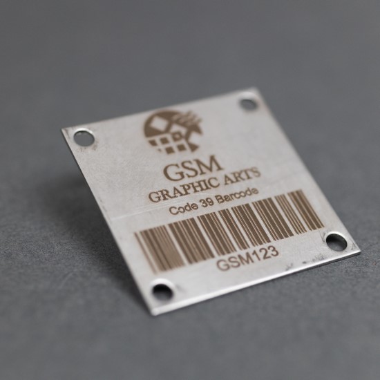 A stainless steel badge with an etched barcode.