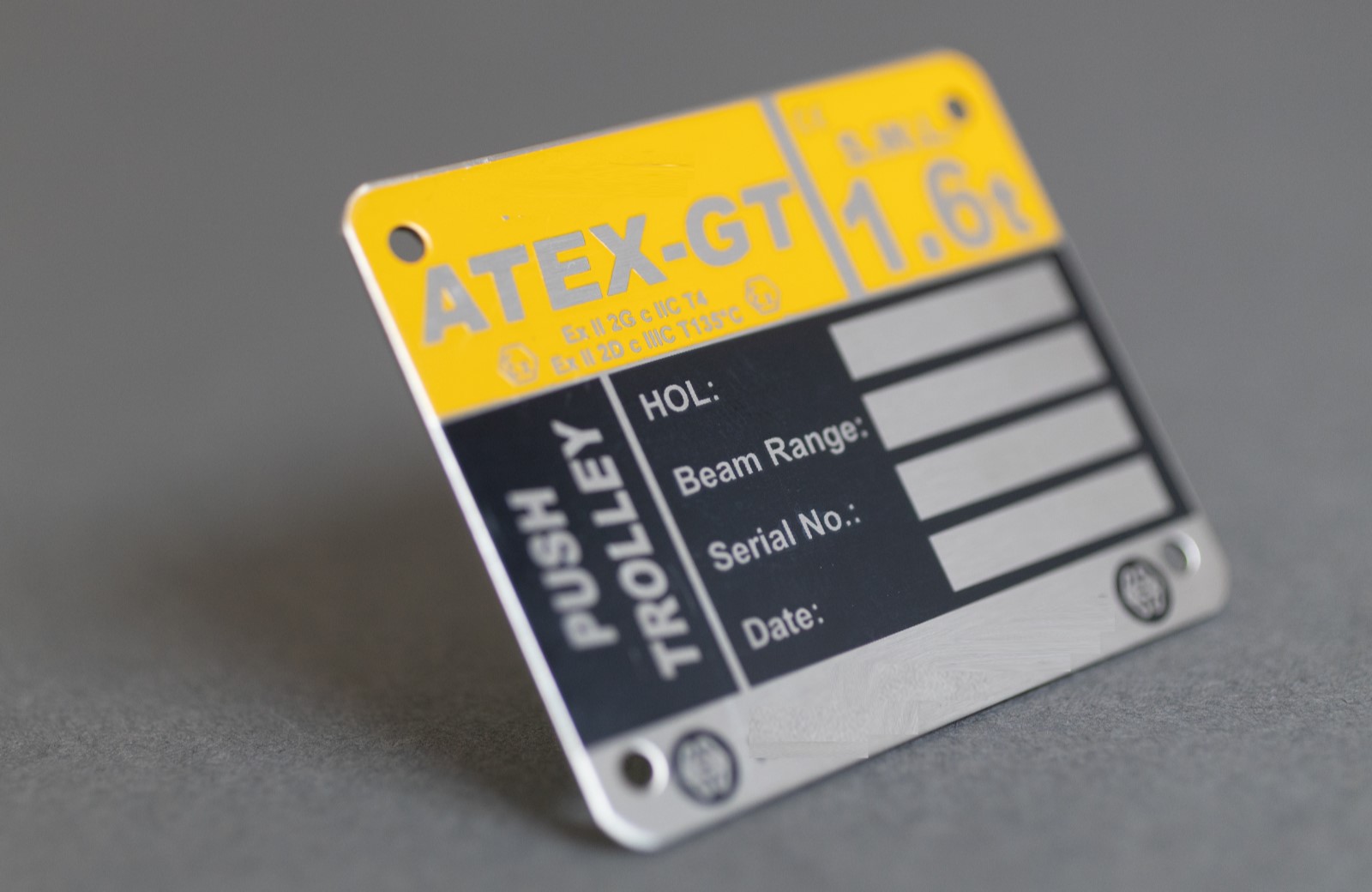 A metal badge with equipment information spaces.